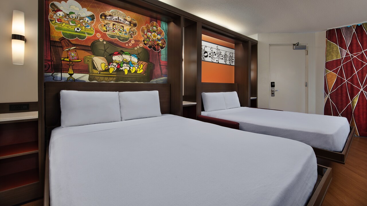 2 beds with Disney artwork above the headboard and wall sconces