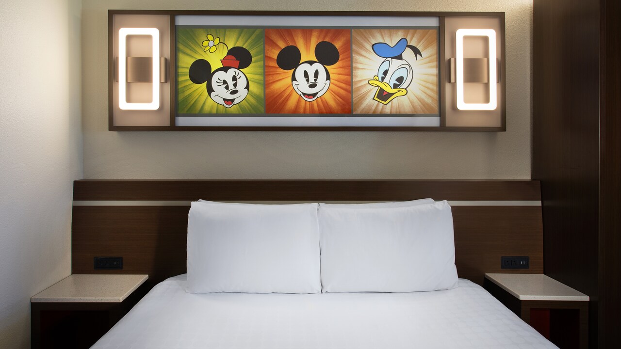 Bed with a night stand and lighted wall art