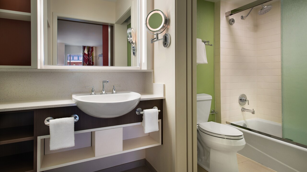 Bathroom sink, mirror, towels and tub