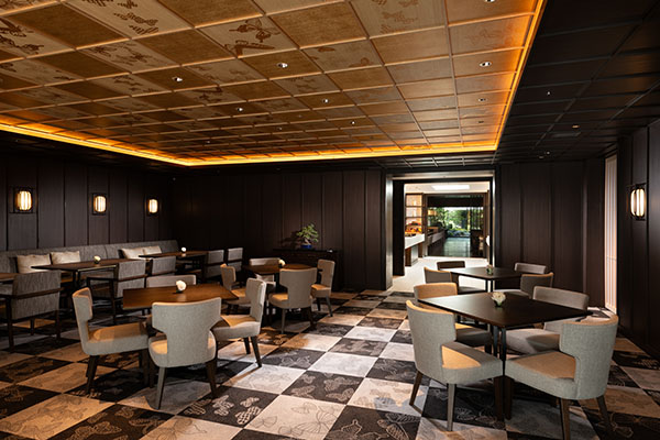Executive lounge with a checkered carpet, dark wood walls, and a coffered ceiling