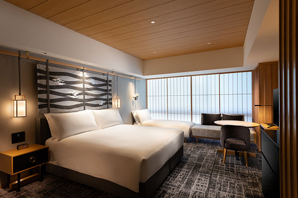 King executive room with a white bed, lantern pendants, and a window seat behind shoji screens