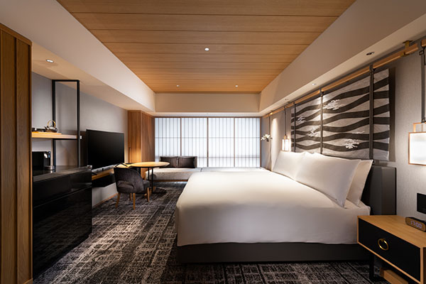 King guest room with a white bed, a wave-pattern headboard, a wood ceiling, and a window seat