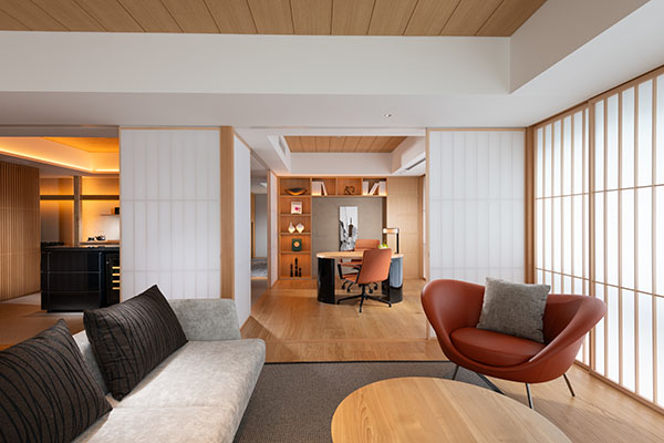 King Premium Suite living room with a sofa, a rust chair, a desk, and shoji along the window