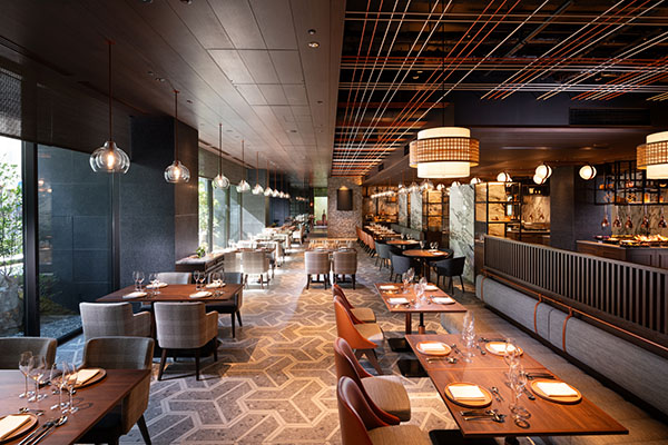 Teori dining room with set tables, pendant lights, and a buffet counter along the right wall