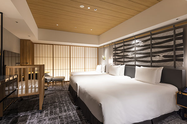 Twin family room with two white beds, a wood crib, and shoji screens along the wall