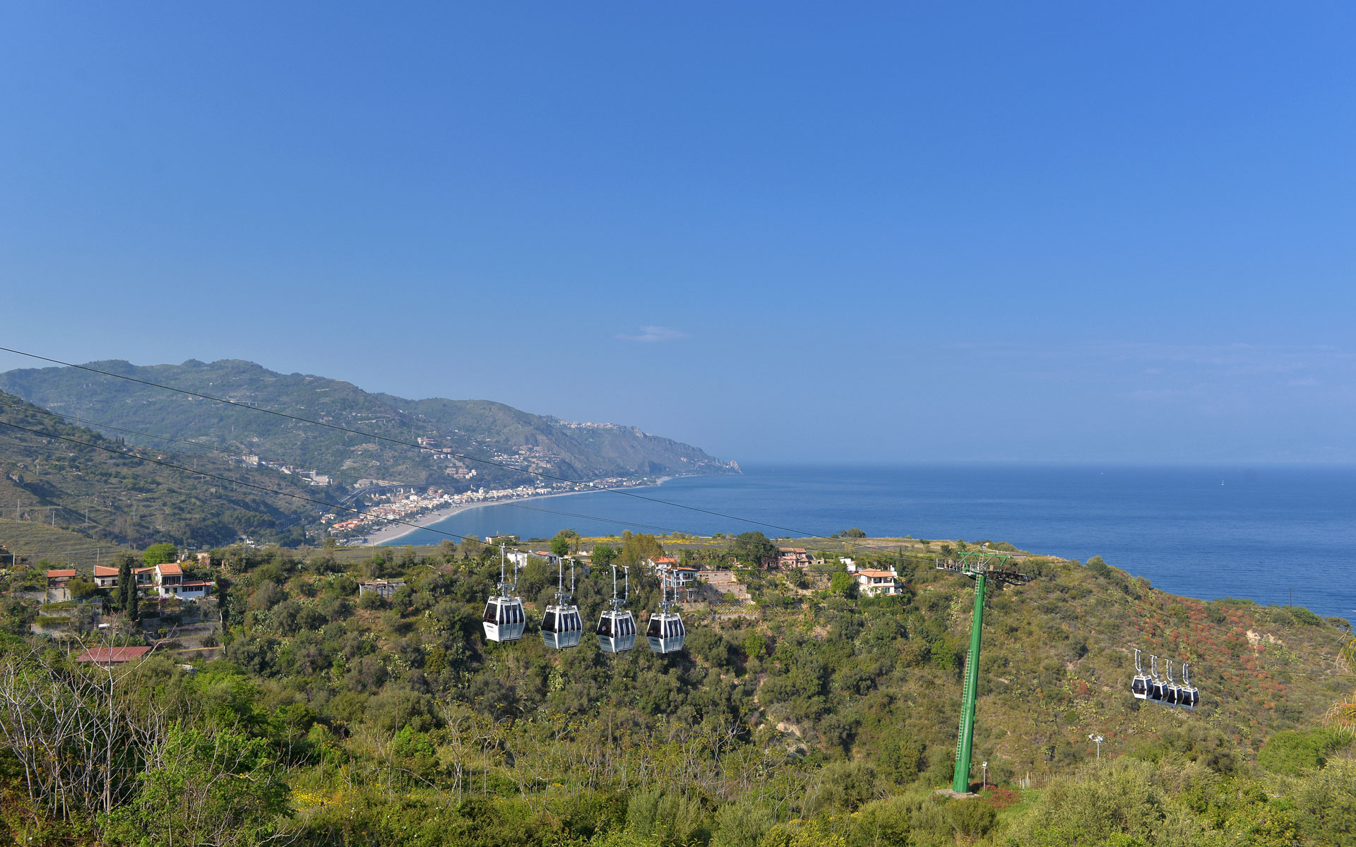 Cable-car gondolas above the Taormina coast and the sea