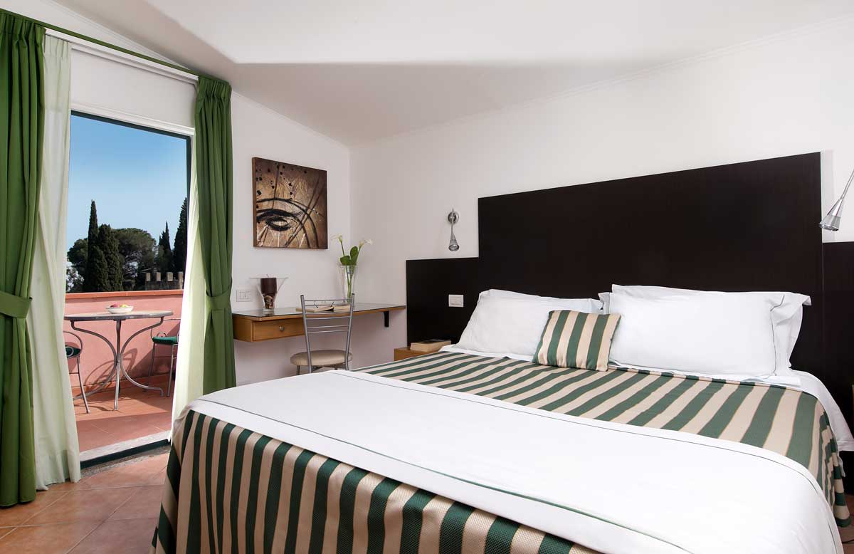 Fourth-floor room with a door open onto a terrace and trees