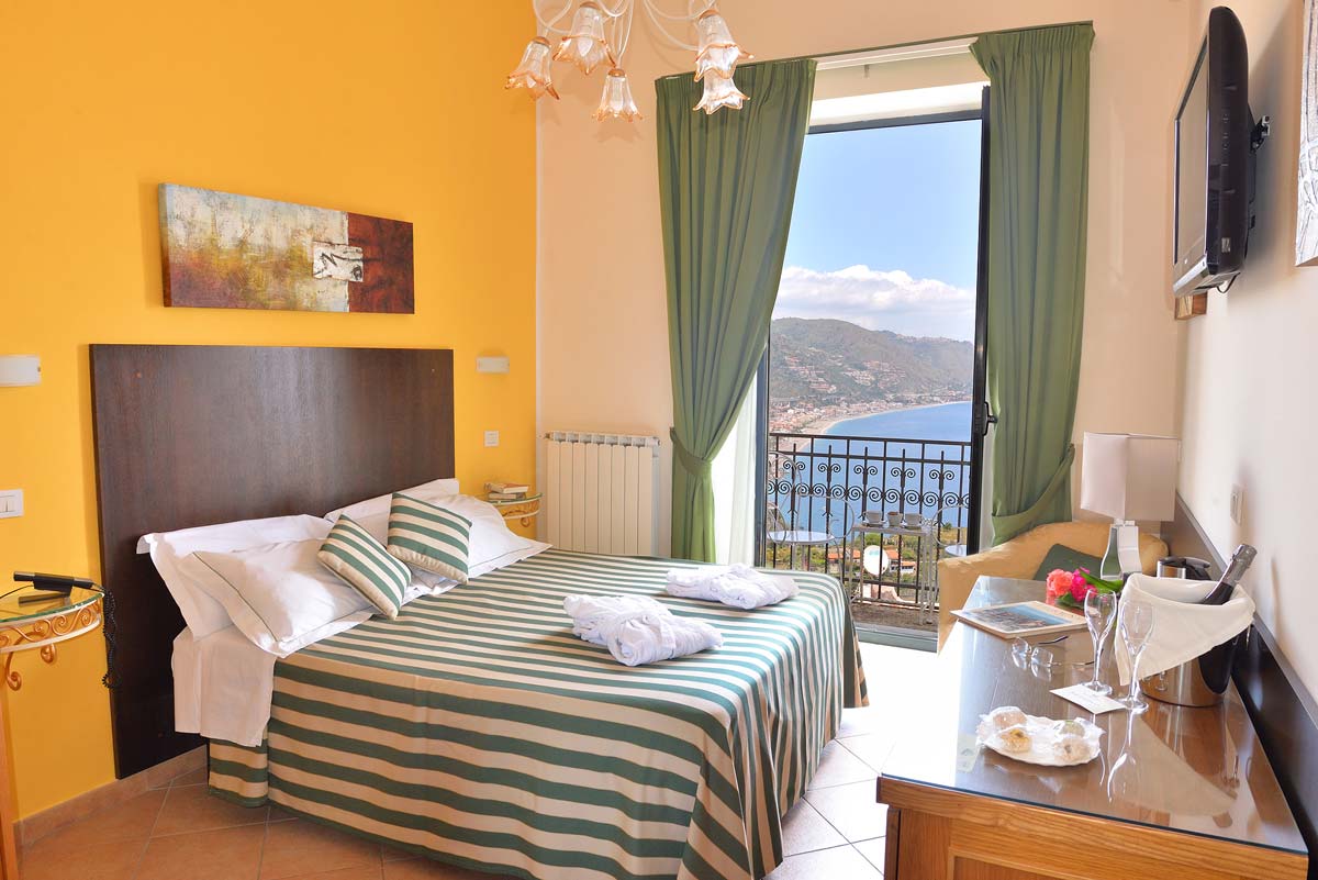 Superior room with balcony doors open onto the bay