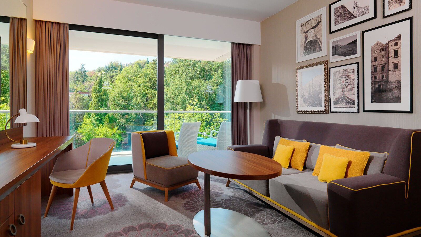 Classic Suite living room with a sofa, yellow pillows, and a balcony over the trees