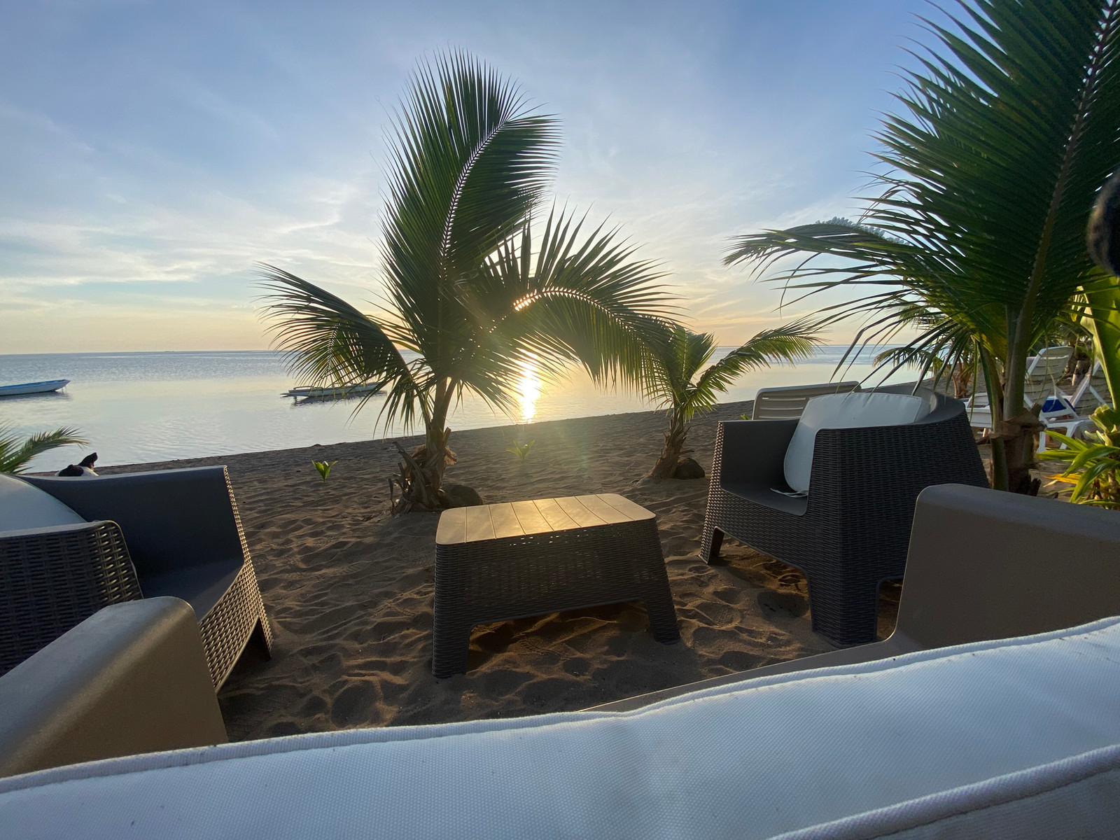 Fare Oaoa Haapiti beachfront lounge chairs on the sand at sunset