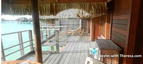 Beach View Overwater Villa balcony with thatched roof and lounge chairs