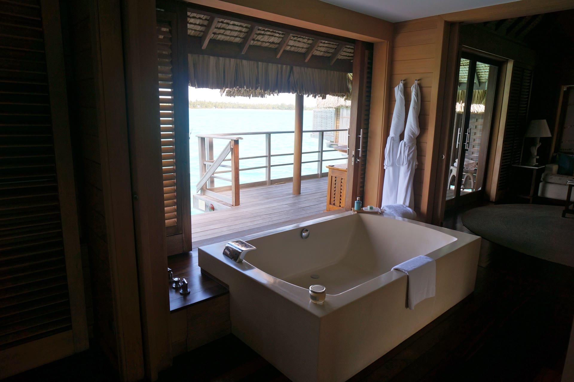 Beachview Overwater Villa soaking tub with open shutters to turquoise lagoon views