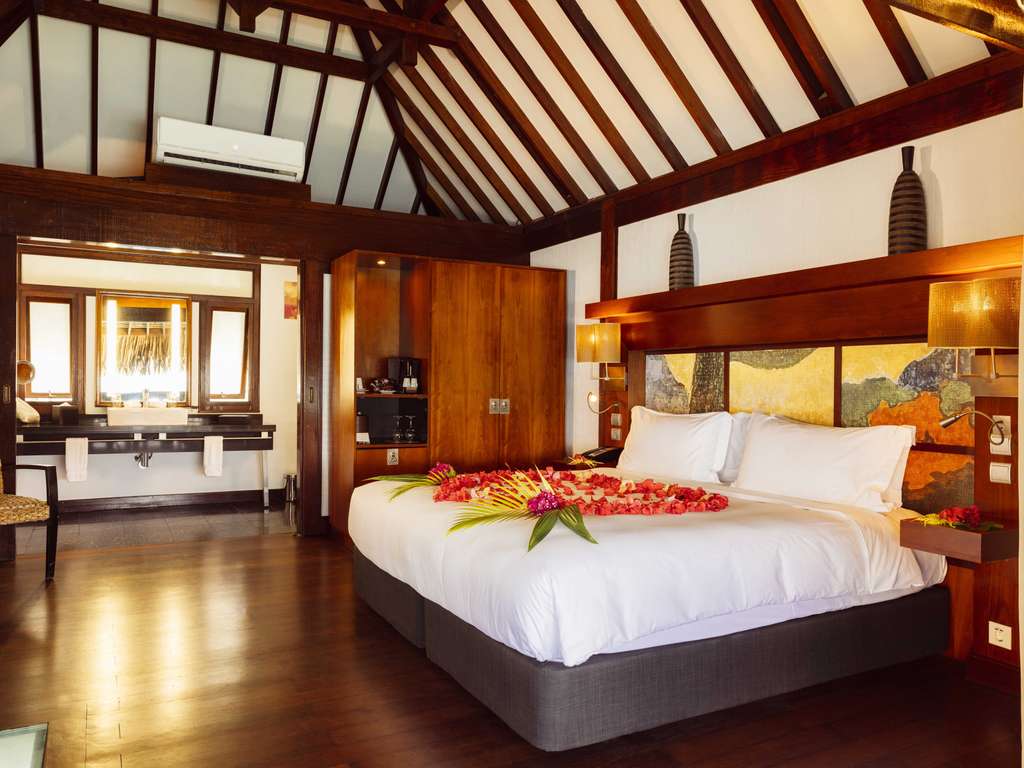 Sofitel Moorea Superior Overwater Villa king bed with honeymoon flower arrangement