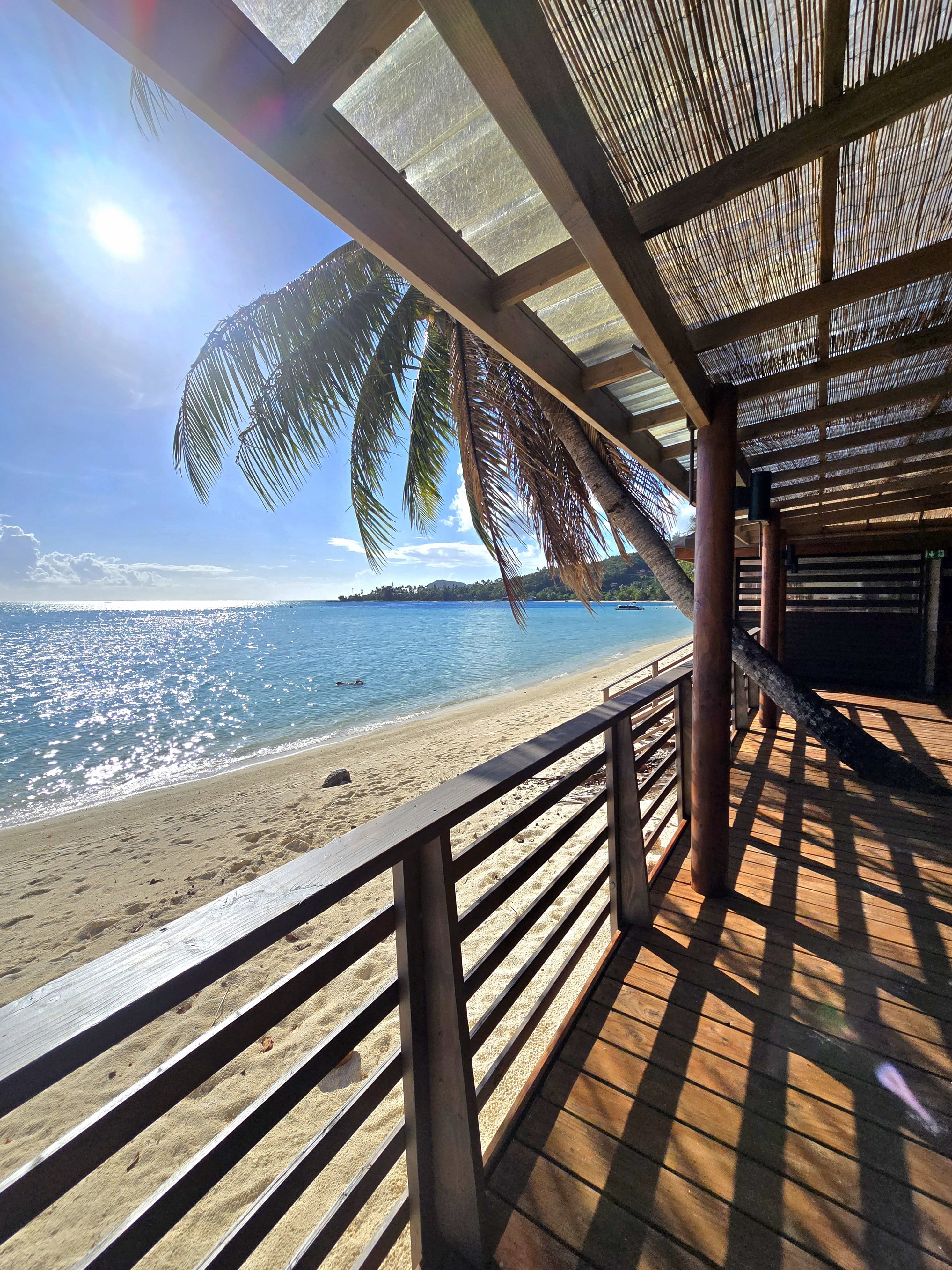 La Bella Matira terrace overlooking white sand, palms and the turquoise lagoon at Matira Beach