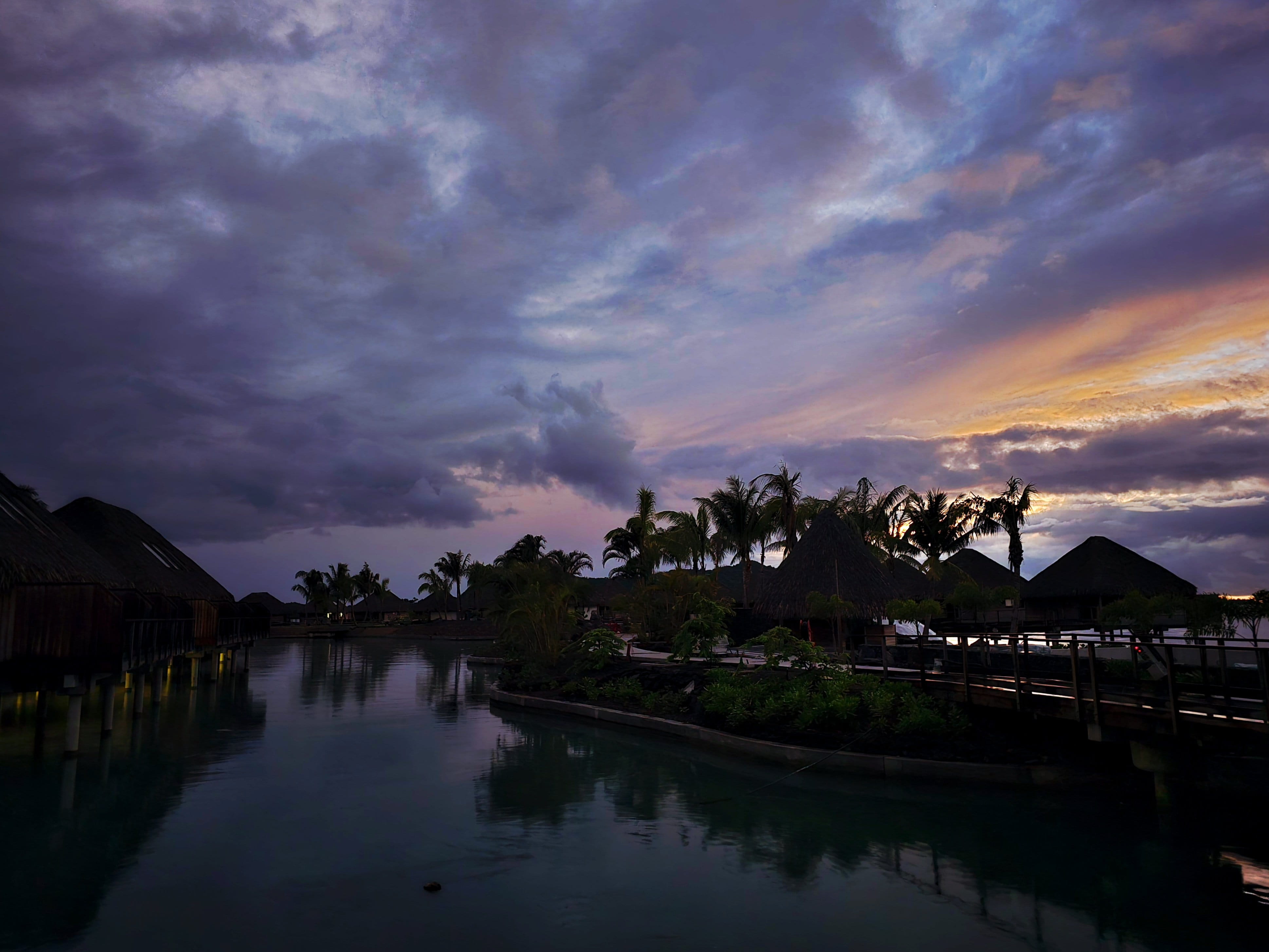 Bloody Mary's Hotel Motu View Rooms at twilight with overwater bungalows on a calm lagoon