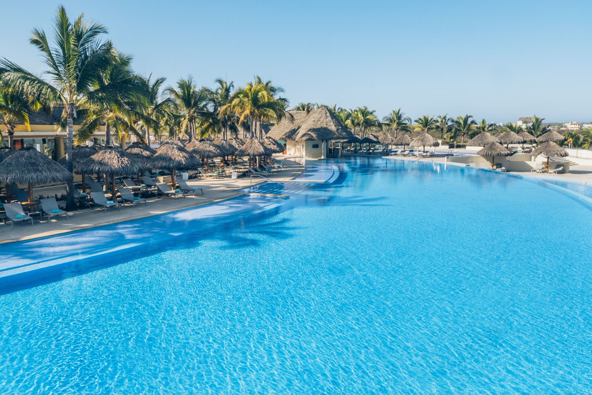 Infinity pool with palapa umbrellas at Iberostar Selection Playa Mita