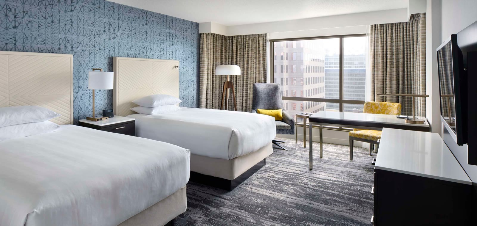 Double/double guest room at Hyatt Regency Vancouver with two beds and a city view