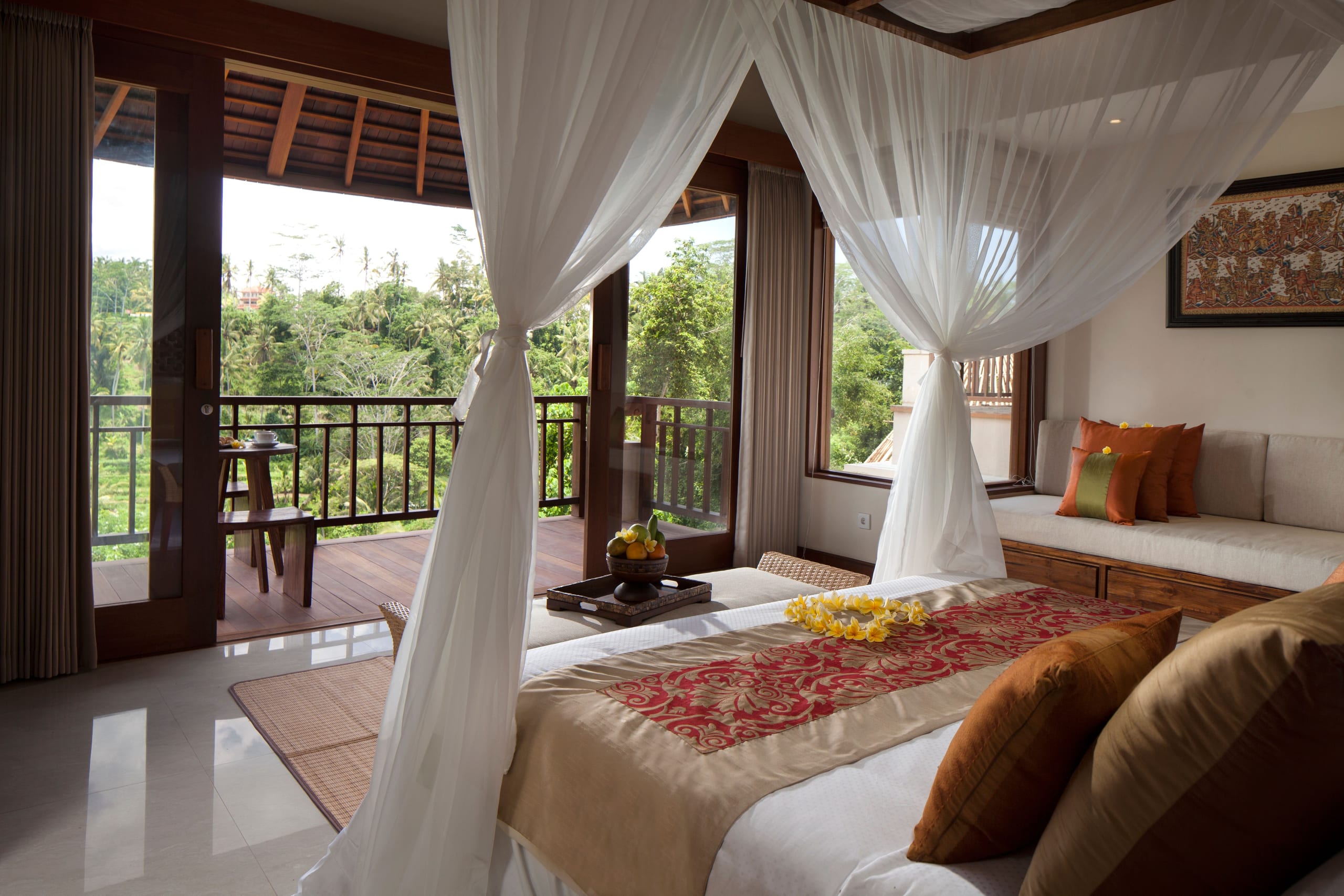 Canopied bed and valley balcony in a Deluxe Suite at Jannata Resort & Spa Ubud
